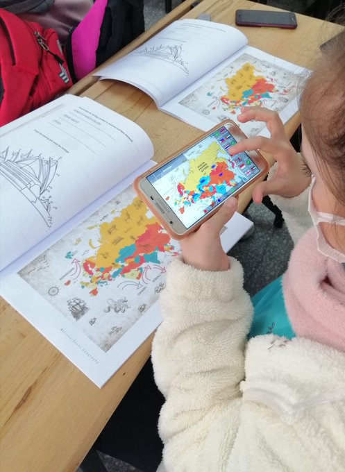 A child holding a phone where a 3D image of a map can be seen